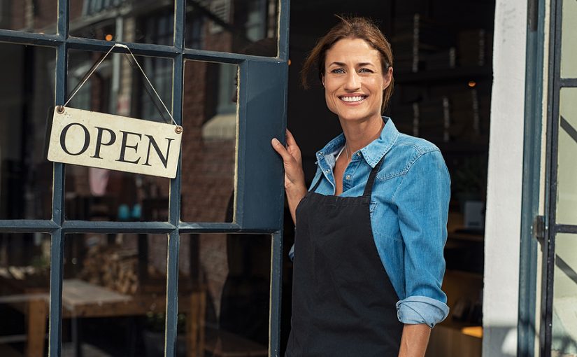 Small Business Owner opening the door of their shop with an open sign.