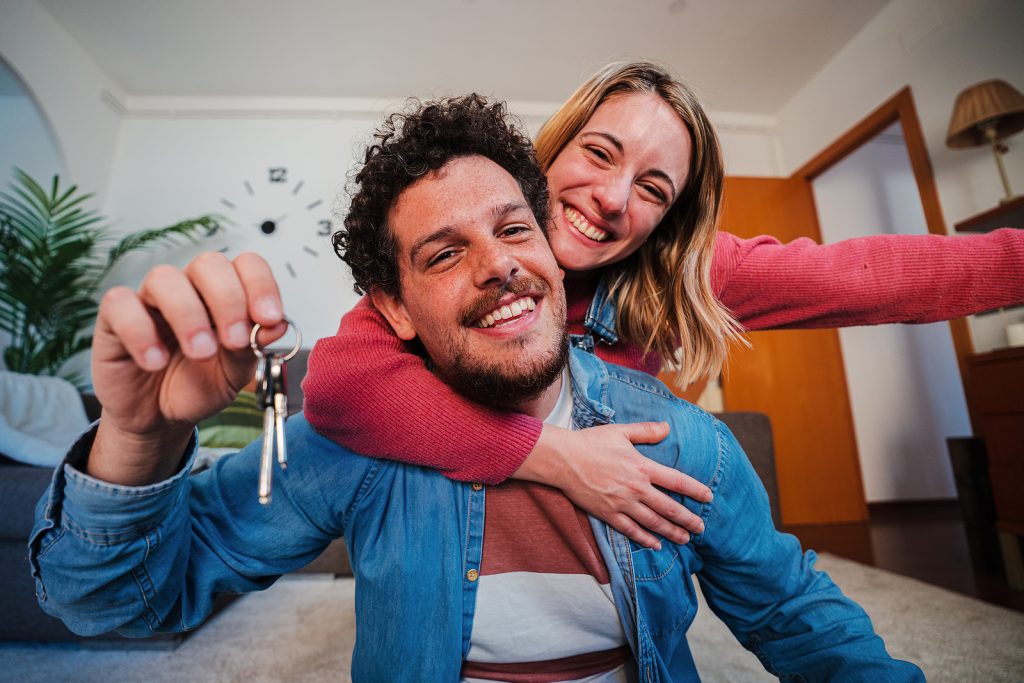 Happy young couple with the keys to their new apartment.