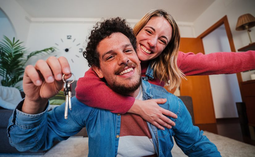 Happy young couple with the keys to their new apartment.