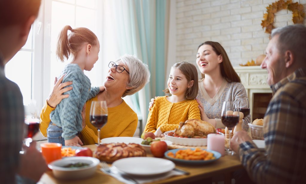 Family and friends gathered around a feast at a holiday party.