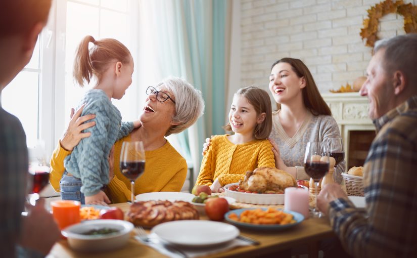 Family and friends gathered around a feast at a holiday party.