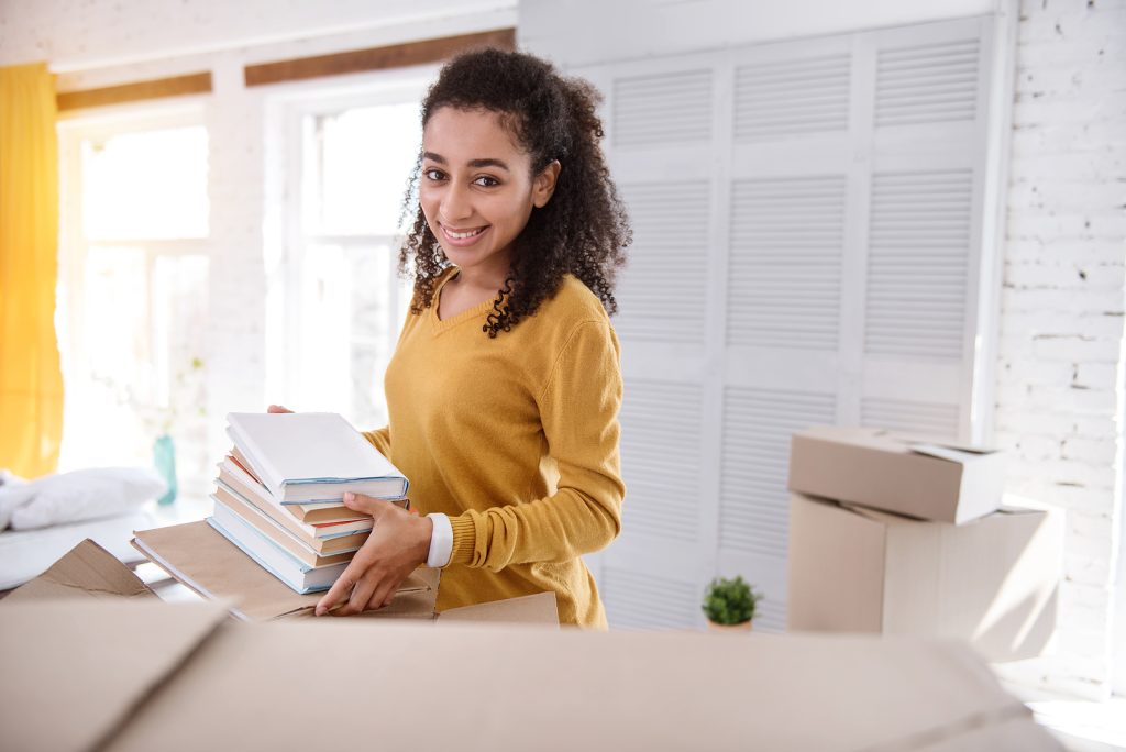 A college student packing up their dorm room to move to an apartment in college.