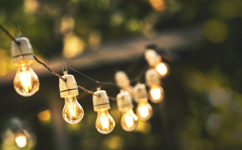 String of lights set up in a backyard as part of an event.