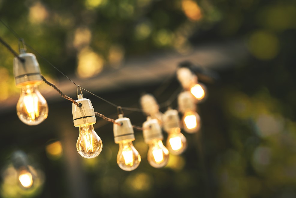 String of lights set up in a backyard as part of an event.