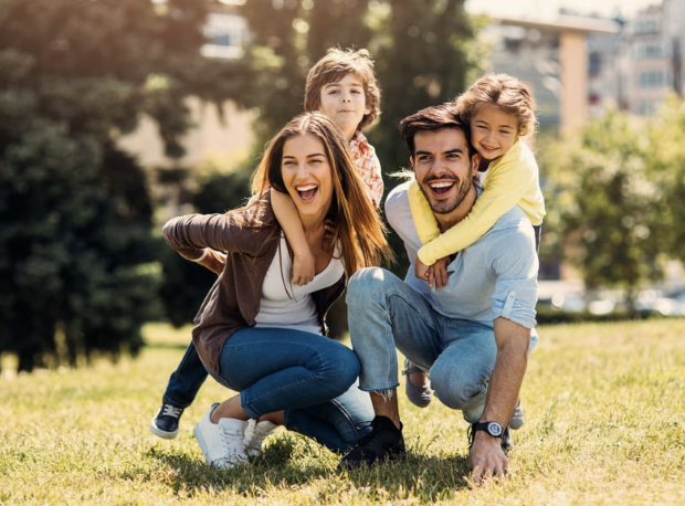 Young family posing together outside.